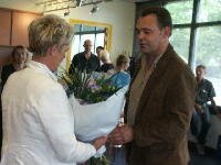 Voorzitter van De Compnist Rob Staal biedt mevrouw Joosten bloemen aan
